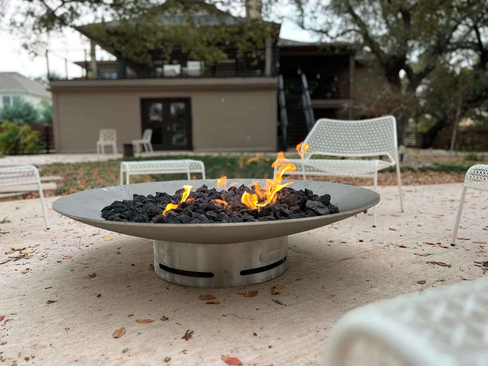 Gas fire pit feature lit with flames, installed and plumbed by Streamline Service