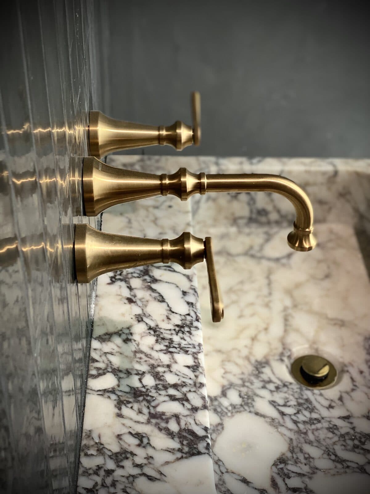 Brushed gold faucet installed on a marble vanity by Streamline Service