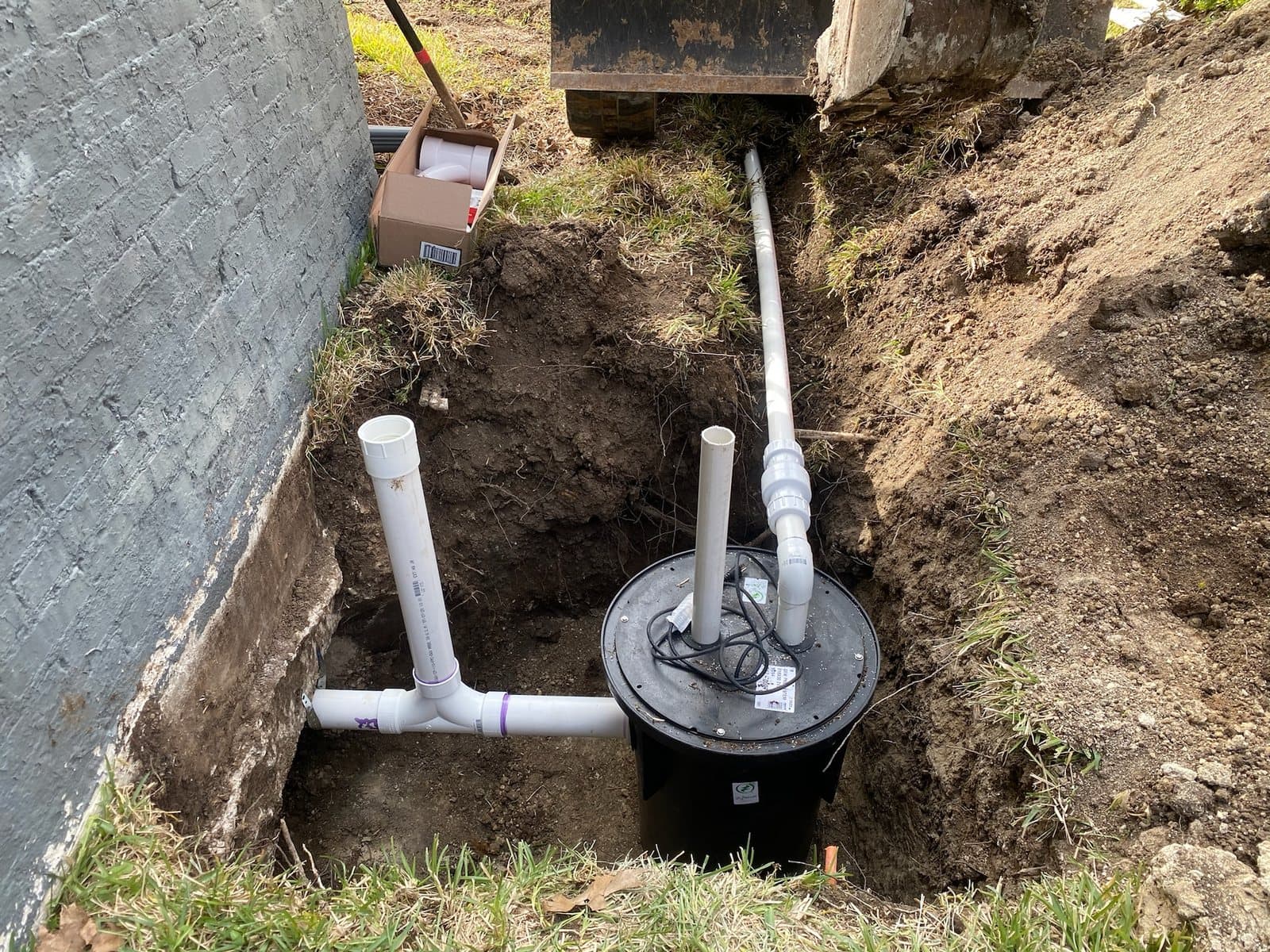 Grinder pump and sewer piping installation beside a home