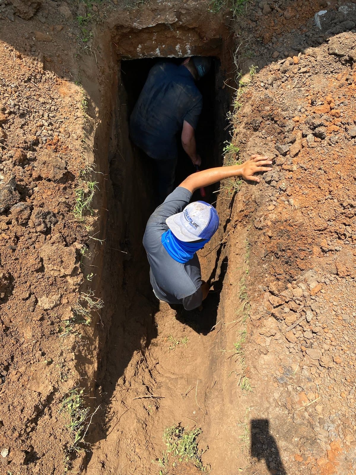 Technician working inside a sewer trench